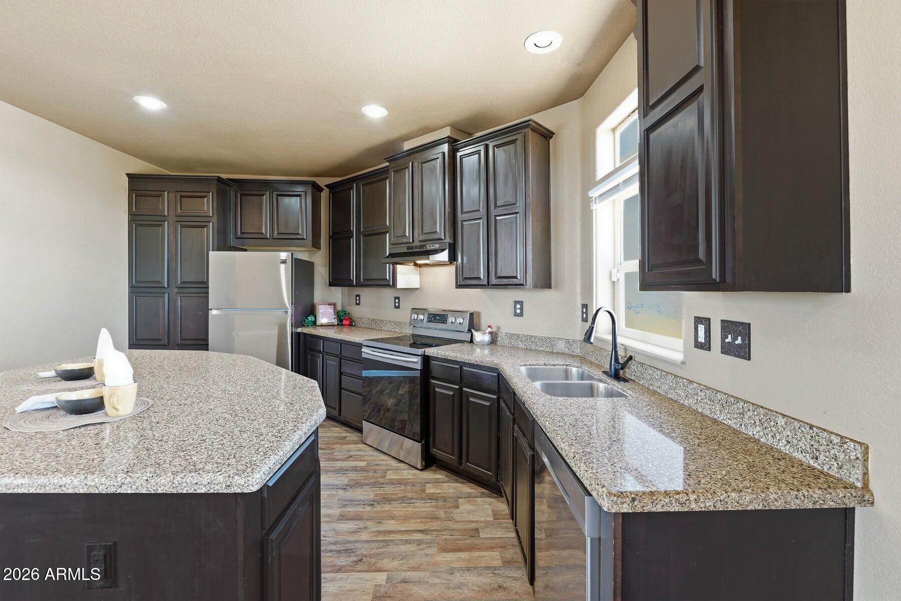 3216 North Mesquite Road Cochise, AZ 85606 - Photo 10 of 39 a kitchen with kitchen island granite countertop a sink stove and refrigerator