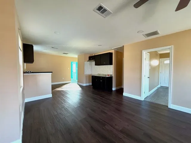 an empty room with wooden floor and fireplace