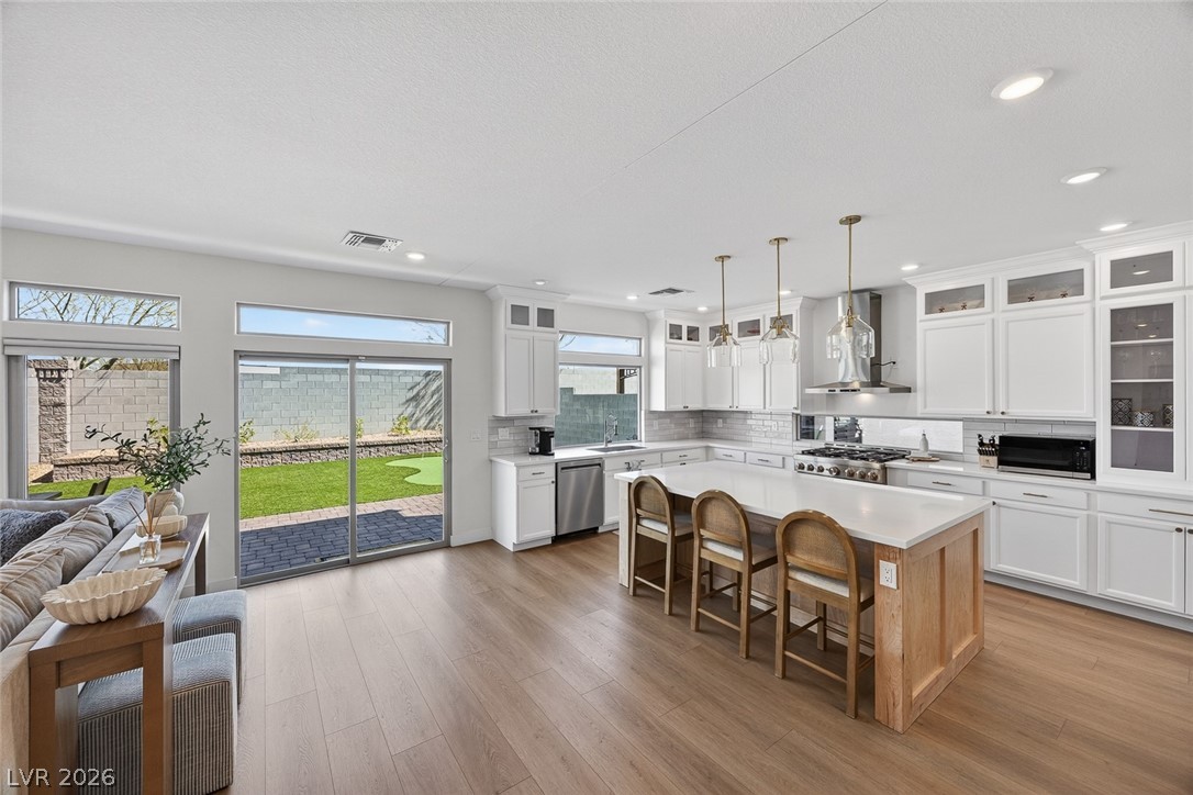 10446 Emerald Rye Street Las Vegas, NV 89183 - Photo 12 of 37 Natural light floods this inviting kitchen and living area, offering seamless indoor-outdoor living.
