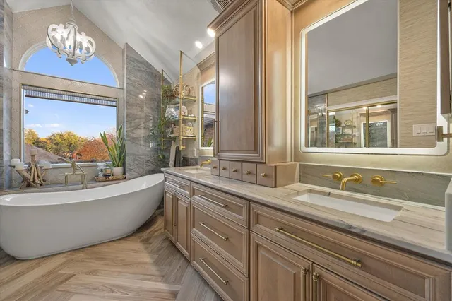 a bathroom with a double vanity sink a a bathtub a mirror and window