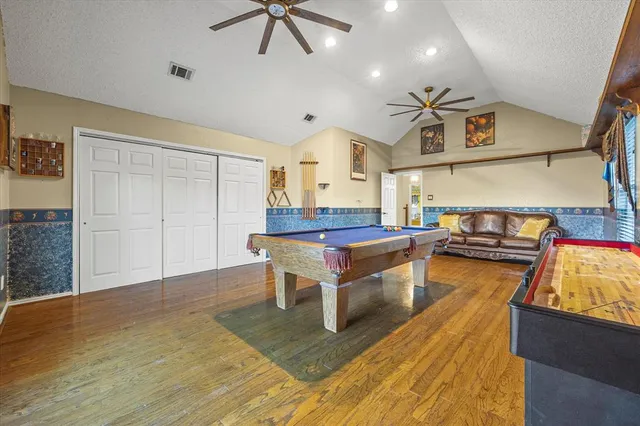 a living room with stainless steel appliances kitchen island granite countertop furniture and a wooden floor