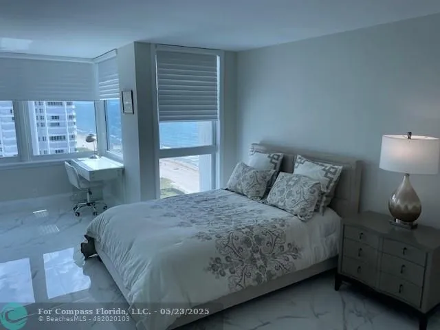 a bedroom with furniture and large window