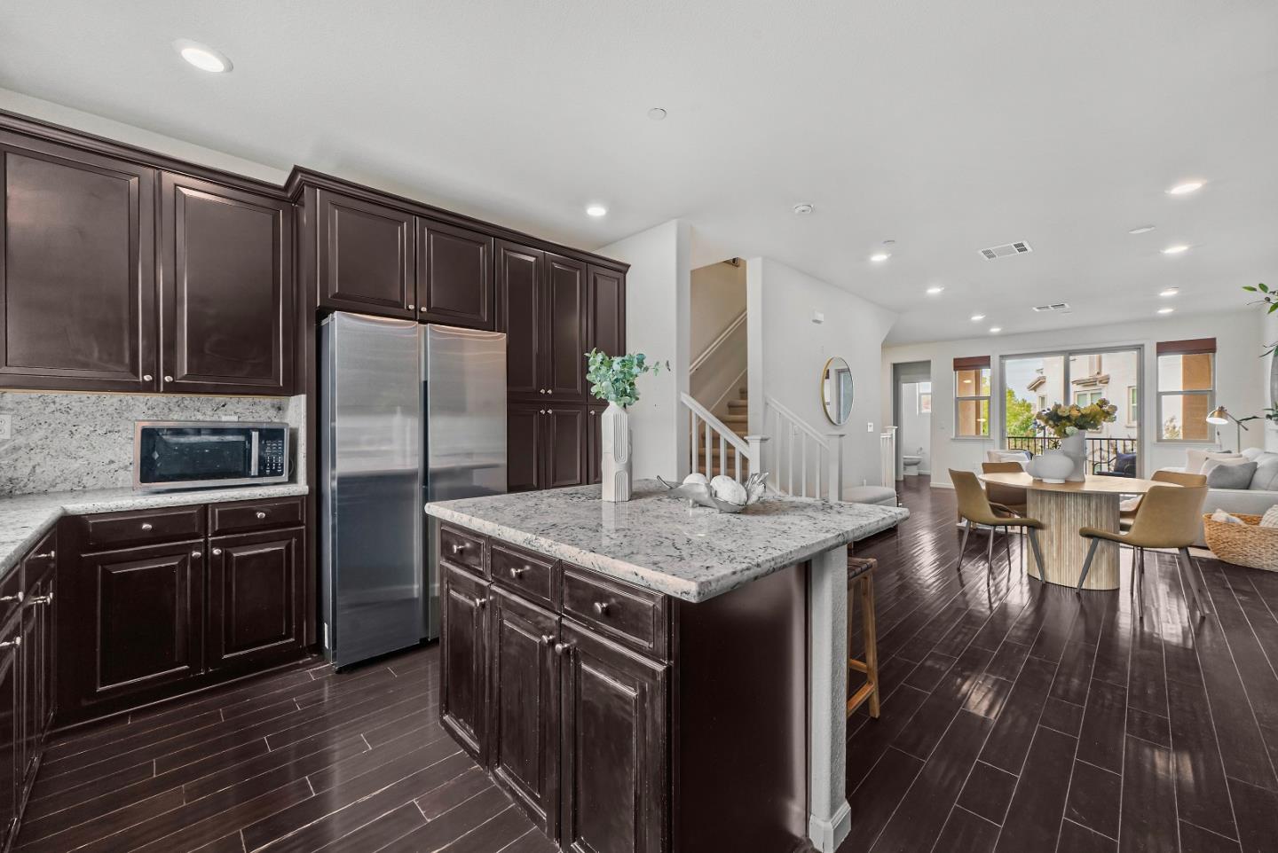 2753 Ferrara Circle San Jose, CA 95111 - Photo 11 of 46 a kitchen with stainless steel appliances granite countertop a table chairs and a refrigerator