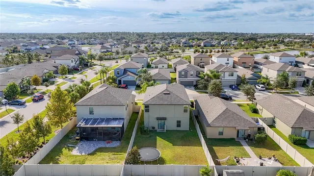 an aerial view of a house with swimming pool and outdoor seating