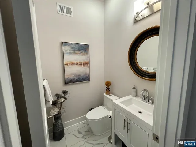 a bathroom with a toilet a sink and a mirror