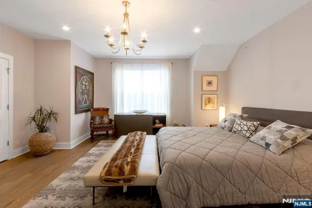 a bedroom with a bed and a chandelier