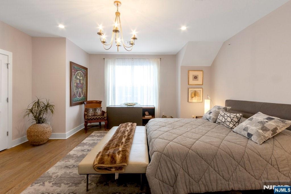 704 Opus Way, Unit 704 Montvale, NJ 07645 - Photo 16 of 33 a bedroom with a bed and a chandelier