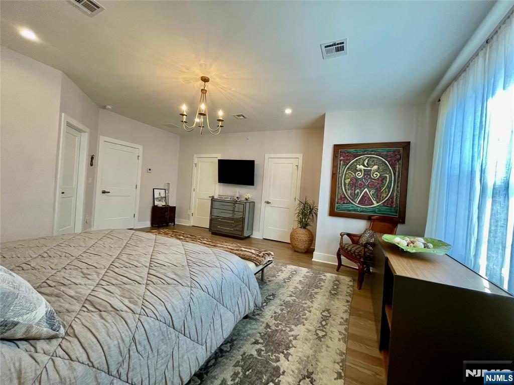 704 Opus Way, Unit 704 Montvale, NJ 07645 - Photo 17 of 33 a spacious bedroom with a bed and a flat screen tv