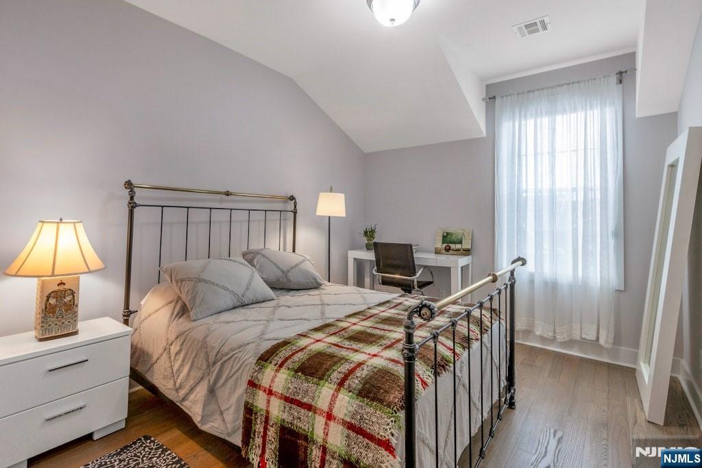 704 Opus Way, Unit 704 Montvale, NJ 07645 - Photo 21 of 33 a bedroom with a bed and a chandelier