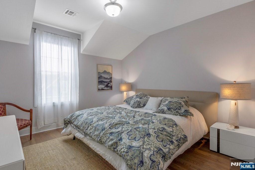 704 Opus Way, Unit 704 Montvale, NJ 07645 - Photo 22 of 33 a bedroom with a bed and a lamp