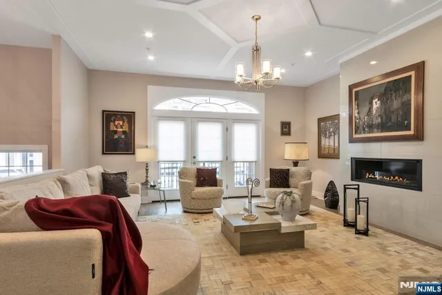 a living room with furniture a chandelier and a fireplace