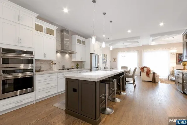 a kitchen with stainless steel appliances granite countertop a stove and a wooden floors