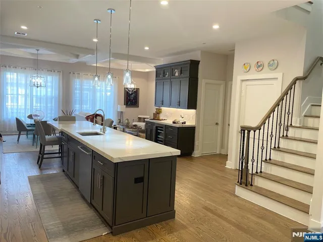 a kitchen with counter top space a sink a stove and wooden floor