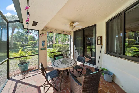 a view of a white house with a big yard and large trees