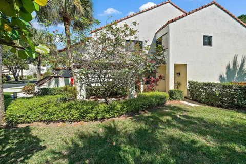 a front view of a house with a garden and yard