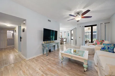 a view of a dining room with furniture a chandelier and wooden floor