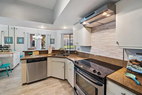 a kitchen with cabinets stainless steel appliances and wooden floor
