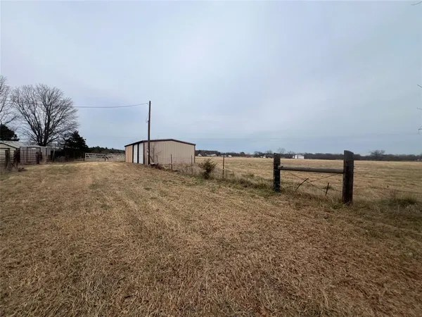 a view of a house with a backyard and trees