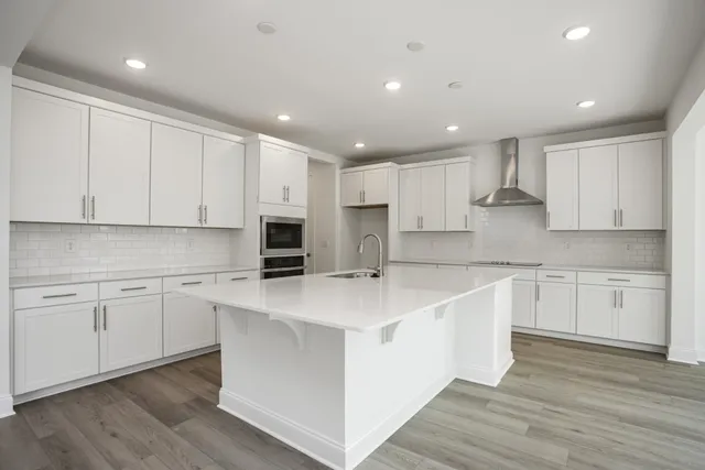 a kitchen with stainless steel appliances granite countertop a white stove top oven and white cabinets