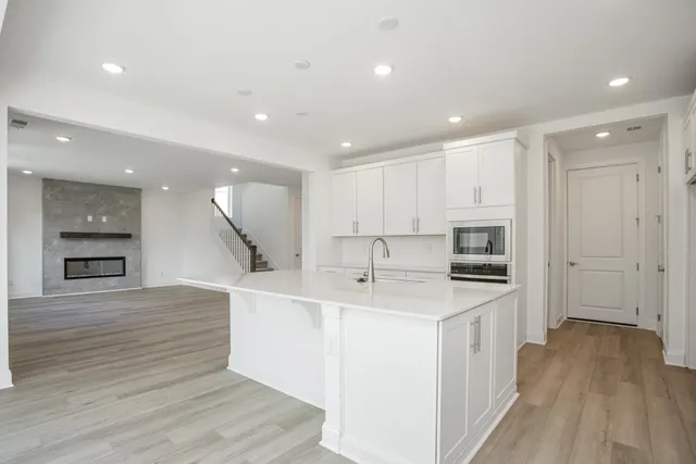 a kitchen with stainless steel appliances sink refrigerator and wooden floor