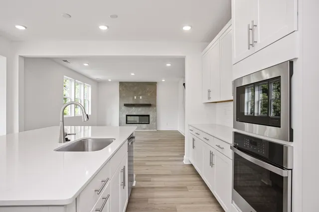a large kitchen with kitchen island a sink stainless steel appliances and cabinets