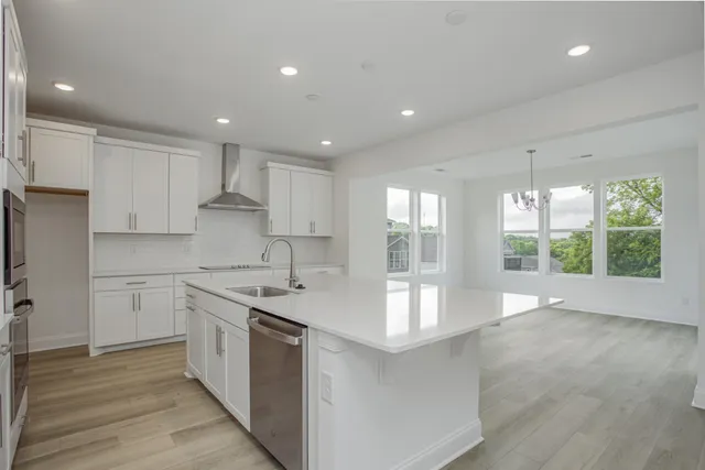 a large kitchen with stainless steel appliances granite countertop a lot of counter space and wooden floors