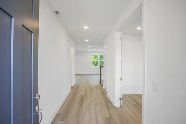 a view of a hallway with wooden floor