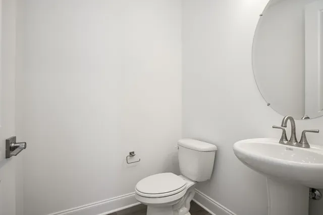 a bathroom with a toilet a sink and mirror