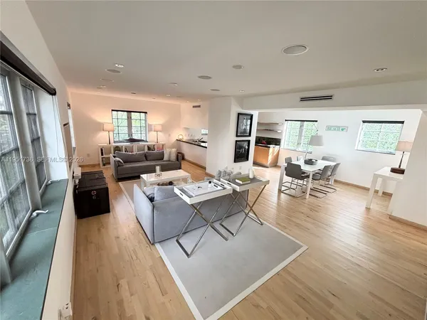 a living room with fireplace furniture wooden floor and a large window