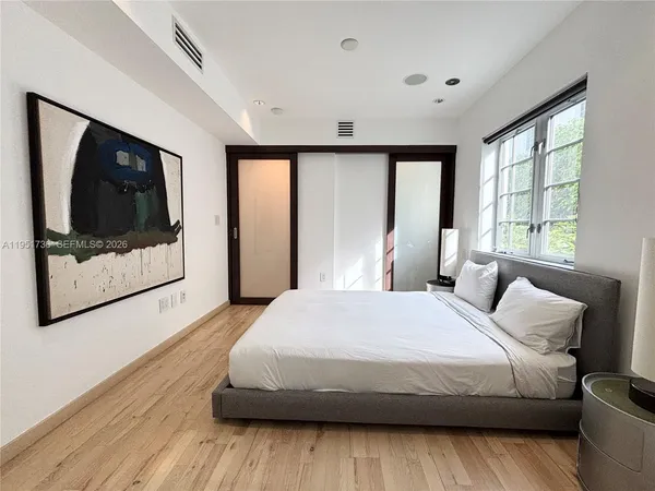 a bedroom with a large bed and a painting on the wall