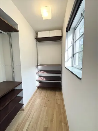 a view of walk in closet with wooden floor