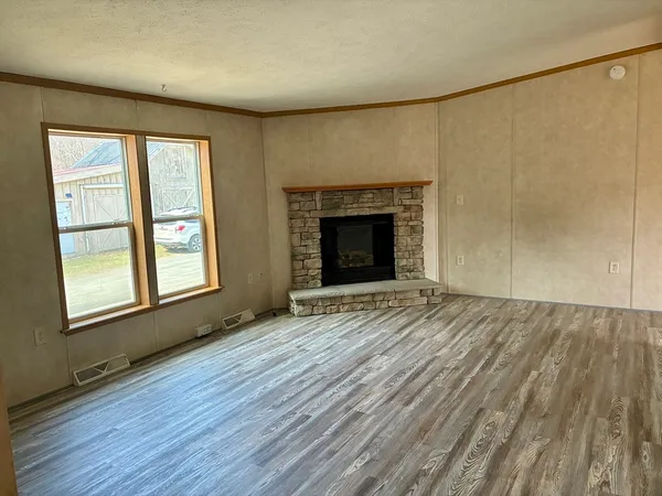 wooden floor fireplace and windows in an empty room