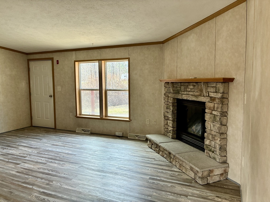 559 Tea Street, Unit 9 Charlemont, MA 01339 - Photo 13 of 21 wooden floor fireplace and windows in an empty room
