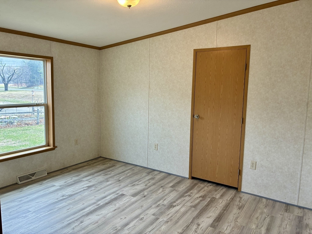 559 Tea Street, Unit 9 Charlemont, MA 01339 - Photo 14 of 21 an empty room with wooden floor and windows