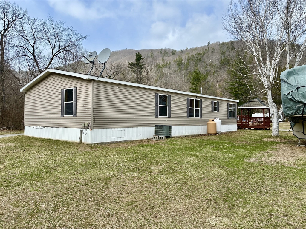 559 Tea Street, Unit 9 Charlemont, MA 01339 - Photo 3 of 21 a backyard of a house with large trees and outdoor seating