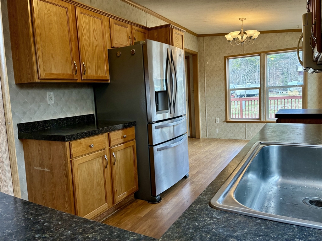 559 Tea Street, Unit 9 Charlemont, MA 01339 - Photo 4 of 21 a kitchen with stainless steel appliances granite countertop a refrigerator a stove and a sink with wooden cabinet