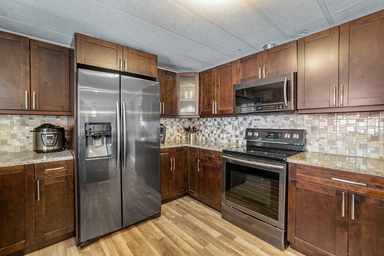 11941 Flotilla Place Boca Raton, FL 33428 - Photo 4 of 21 a kitchen with stainless steel appliances granite countertop a refrigerator a stove a sink and a microwave