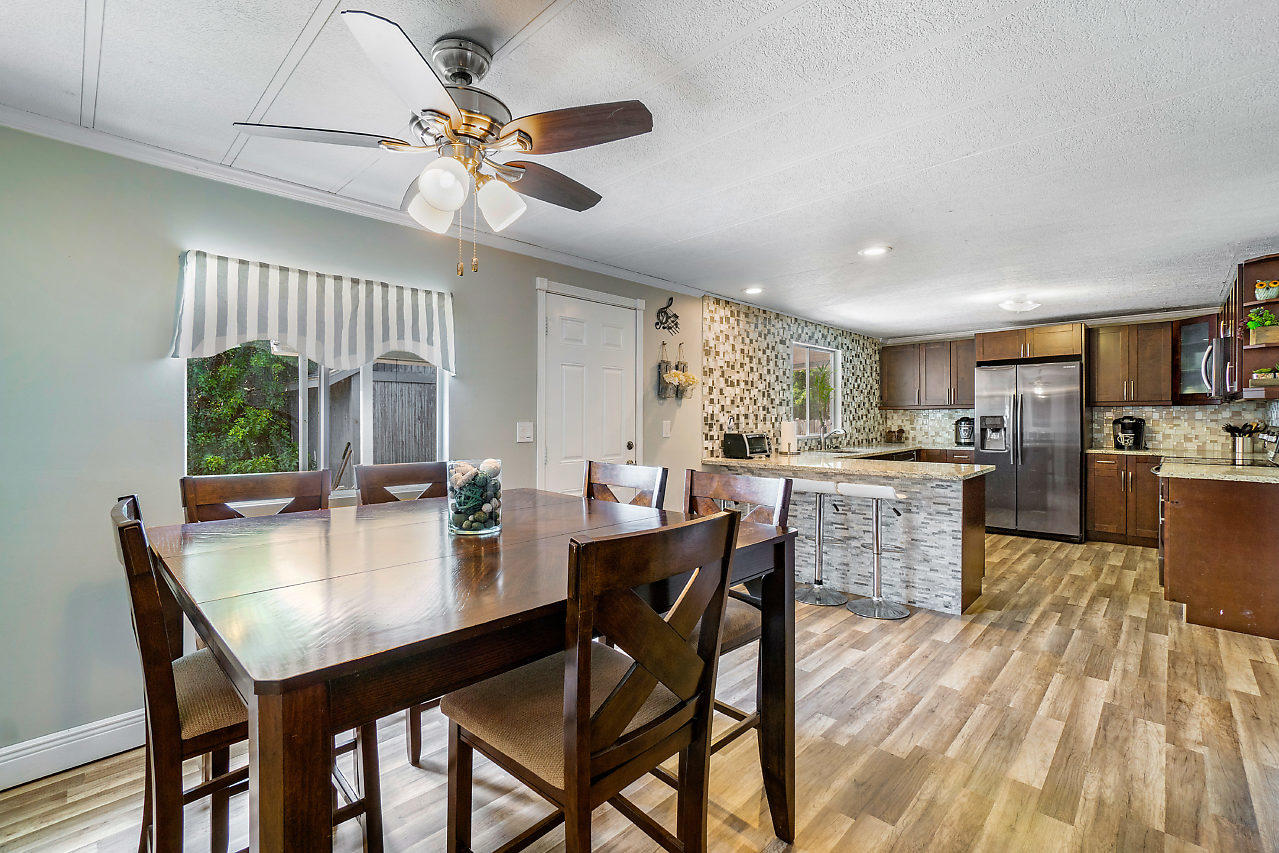 11941 Flotilla Place Boca Raton, FL 33428 - Photo 6 of 21 a open dining room with stainless steel appliances kitchen island granite countertop furniture and a livingroom view