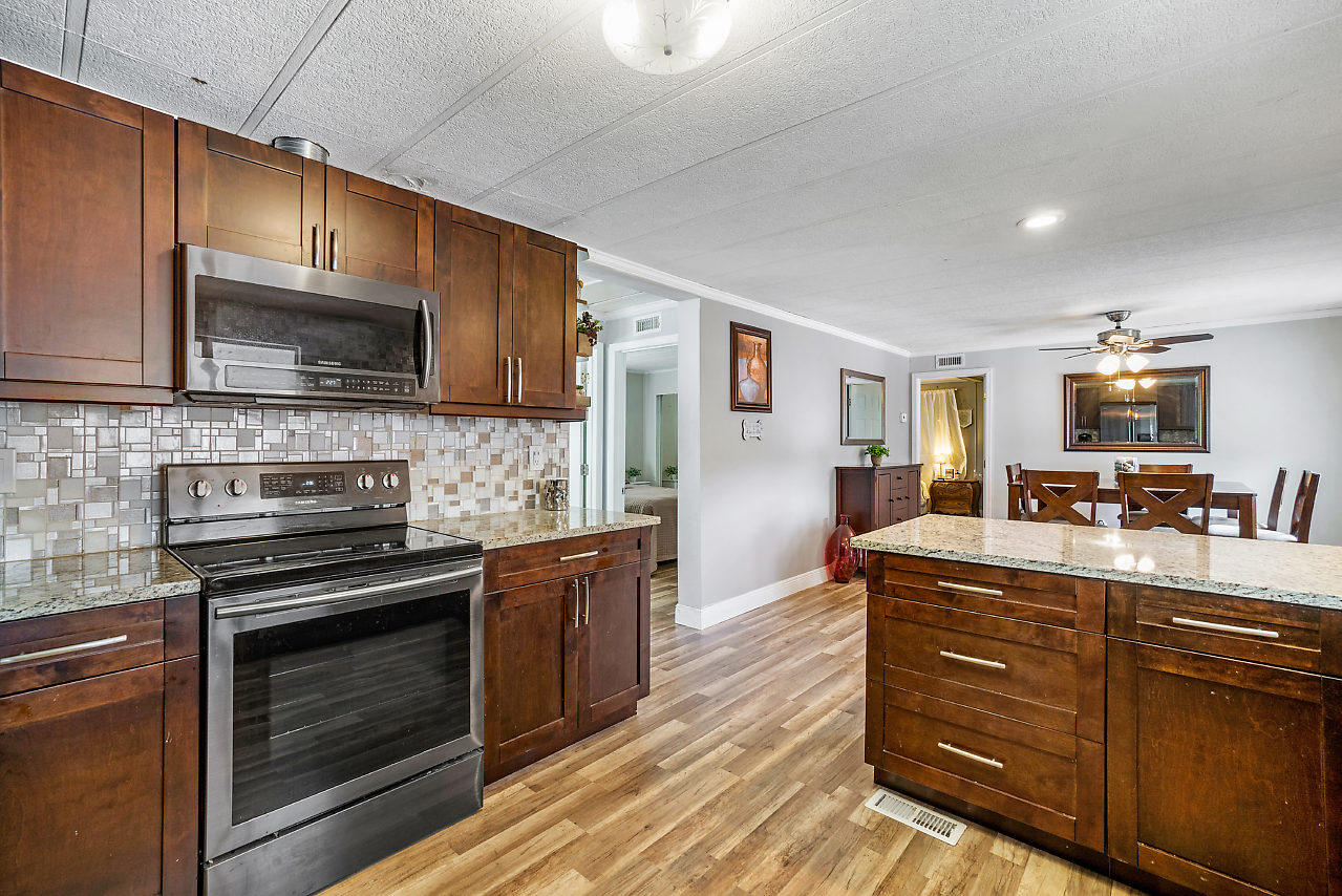11941 Flotilla Place Boca Raton, FL 33428 - Photo 7 of 21 a kitchen with stainless steel appliances kitchen island granite countertop a stove microwave and cabinets