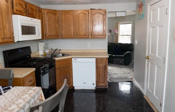 a kitchen with stainless steel appliances a stove a sink cabinets and a wooden floor