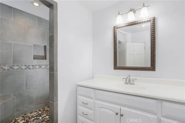 a bathroom with a sink a vanity a shower and a mirror