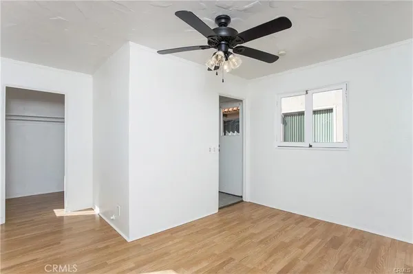 a view of a big room with wooden floor and a ceiling fan