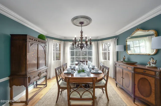 a view of a dining room with furniture wooden floor and chandelier