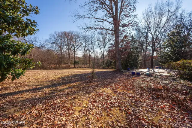 a view of a backyard with table and chairs and a fire pit