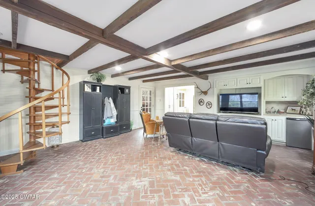 a living room with fireplace furniture and a large window