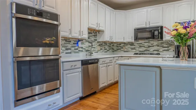 a kitchen with stainless steel appliances granite countertop a stove microwave and refrigerator