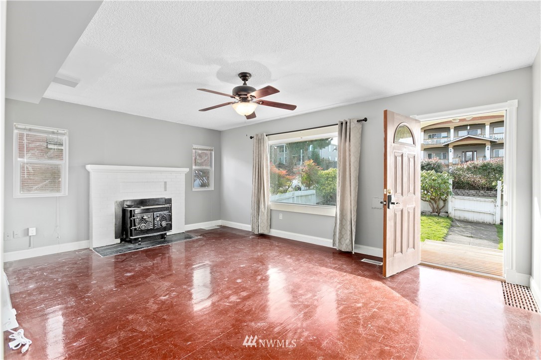 3709 Rockefeller Avenue Everett, WA 98201 - Photo 3 of 12 a view of an empty room with a fireplace and a window