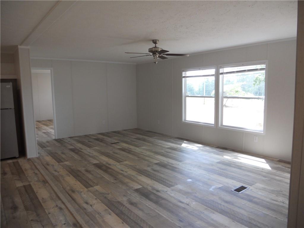 57 Highland Tree Court Ranger, GA 30734 - Photo 19 of 39 an empty room with wooden floor ceiling fan and windows