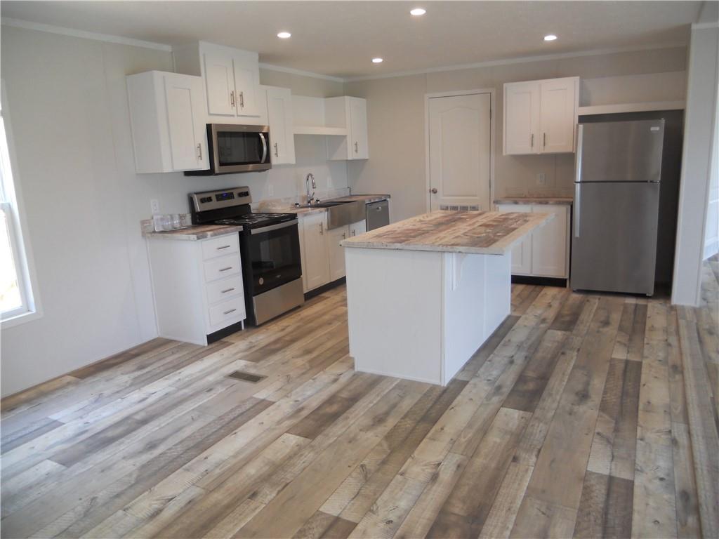 57 Highland Tree Court Ranger, GA 30734 - Photo 21 of 39 a kitchen with a sink a microwave a refrigerator and cabinets