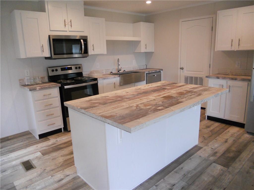 57 Highland Tree Court Ranger, GA 30734 - Photo 22 of 39 a kitchen with stainless steel appliances kitchen island granite countertop a stove a sink and a microwave